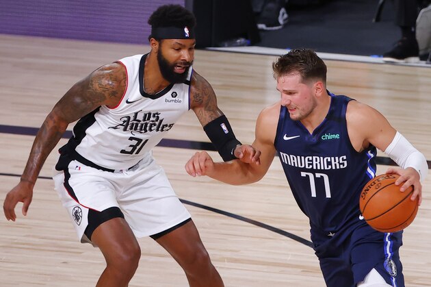 Dallas Mavericks' Luka Doncic (77) drives against Los Angeles Clippers' Marcus Morris Sr. (31) during the first quarter of Game 4 of an NBA basketball first-round playoff series, Sunday, Aug. 23, 2020, in Lake Buena Vista, Fla. (Kevin C. Cox/Pool Photo via AP)