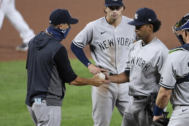 New York Yankees manager Aaron Boone, left, removes Deivi Garcia during the fifth inning of the second baseball game of the team's doubleheader against the Baltimore Orioles, Friday, Sept. 4, 2020, in Baltimore. (AP Photo/Nick Wass)