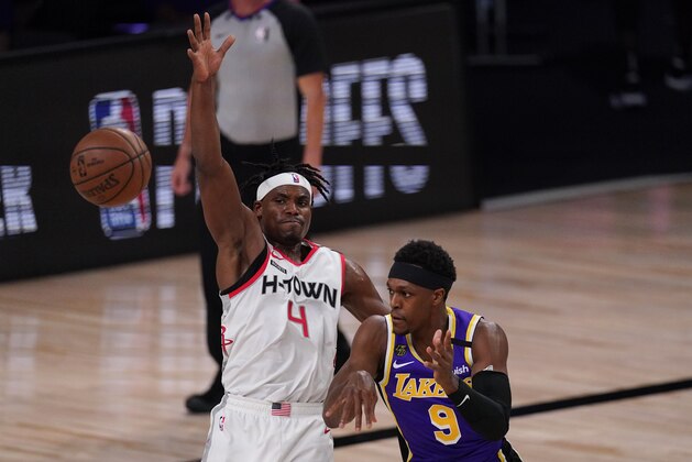Los Angeles Lakers' Rajon Rondo (9) passes in front of Houston Rockets' Danuel House Jr. (4) during the first half of an NBA conference semifinal playoff basketball game Friday, Sept. 4, 2020, in Lake Buena Vista, Fla. (AP Photo/Mark J. Terrill)