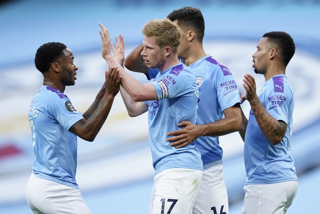 Manchester City's Kevin De Bruyne is congratulated by teammates after scoring his team's first goal during the English Premier League soccer match between Manchester City and Liverpool at Etihad Stadium in Manchester, England, Thursday, July 2, 2020. (AP Photo/Dave Thompson,Pool)