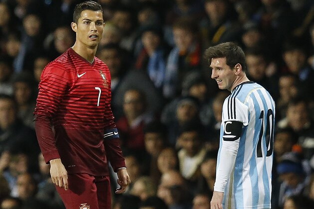 Cristiano Ronaldo of Portugal, left, and Lionel Messi of Argentina stand next to each other during their International Friendly soccer match at Old Trafford Stadium, Manchester, England, Tuesday Nov. 18, 2014. (AP Photo/Jon Super)