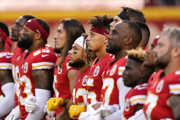 Kansas City Chiefs players, including quarterback Patrick Mahomes (15), stand for a presentation on social justice before an NFL football game against the Houston Texans Thursday, Sept. 10, 2020, in Kansas City, Mo. (AP Photo/Charlie Riedel)