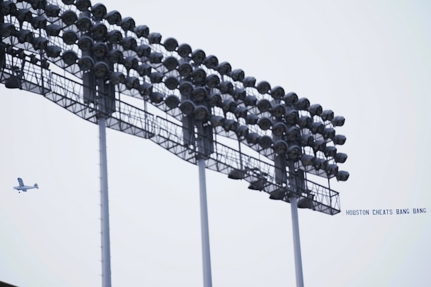 An airplane pulls a sign while circling above Dodger Stadium before a baseball game between the Houston Astros and Los Angeles Dodgers on Saturday, Sept. 12, 2020, in Los Angeles. (AP Photo/Ashley Landis)