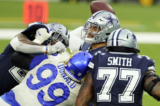 Dallas Cowboys quarterback Dak Prescott, top, throws under pressure from Los Angeles Rams defensive end Aaron Donald (99) during the first half of an NFL football game Sunday, Sept. 13, 2020, in Inglewood, Calif. (AP Photo/Ashley Landis )