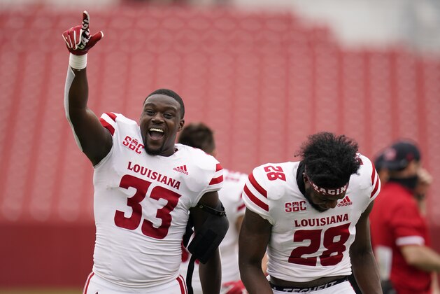 Louisiana-Lafayette linebacker Tyler Guidry (33) and teammate Ja'len Johnson (28) celebrate as they run off the field after an NCAA college football game against Iowa State, Saturday, Sept. 12, 2020, in Ames, Iowa. Louisiana-Lafayette won 31-14. (AP Photo/Charlie Neibergall)