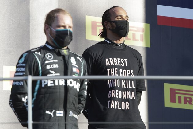 Mercedes driver Lewis Hamilton of Britain, right, is flanked by Mercedes driver Valtteri Bottas of Finland on the podium after winning the Formula One Grand Prix of Tuscany, at the Mugello circuit in Scarperia, Italy, Sunday, Sept. 13, 2020. (AP Photo/Luca Bruno, Pool)