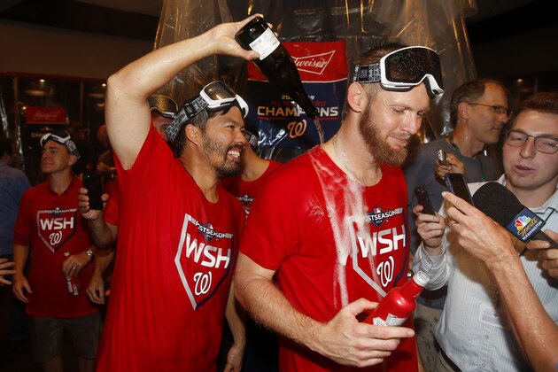 Washington Nationals catcher Kurt Suzuki, left, pours champagne on teammate Stephen Strasburg as they celebrate after winning a National League wild-card baseball game against the Milwaukee Brewers, Tuesday, Oct. 1, 2019, in Washington. Washington won 4-3. (AP Photo/Patrick Semansky)