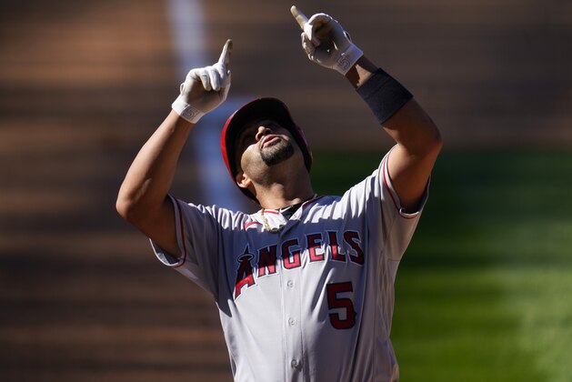 Los Angeles Angels' Albert Pujols gestures as he crosses home plate after hitting a two-run home run of Colorado Rockies relief pitcher Carlos Estevez in the eighth inning of a baseball game Sunday, Sept. 13, 2020, in Denver. (AP Photo/David Zalubowski)