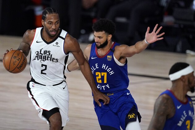 Los Angeles Clippers' Kawhi Leonard, left, dribbles against Denver Nuggets' Jamal Murray during the second half of an NBA conference semifinal playoff basketball game, Friday, Sept. 11, 2020, in Lake Buena Vista, Fla. (AP Photo/Mark J. Terrill)