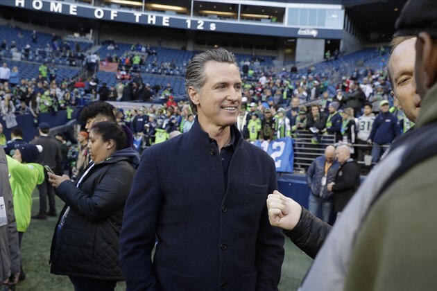 California Gov. Gavin Newsom talks on the field before an NFL football game between the Seattle Seahawks and the San Francisco 49ers, Sunday, Dec. 29, 2019, in Seattle. (AP Photo/Ted S. Warren)