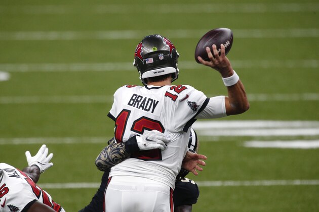 Tampa Bay Buccaneers quarterback Tom Brady (12) passes under pressure from New Orleans Saints outside linebacker Demario Davis in the second half of an NFL football game in New Orleans, Sunday, Sept. 13, 2020. (AP Photo/Butch Dill)