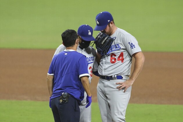 Los Angeles Dodgers relief pitcher Caleb Ferguson, right, talks with manager Dave Roberts, middle, and a trainer after facing San Diego Padres' Jurickson Profar during the eighth inning of a baseball game Tuesday, Sept. 15, 2020, in San Diego. Ferguson left the game after the meeting. (AP Photo/Derrick Tuskan)