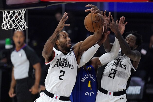 Los Angeles Clippers' Kawhi Leonard (2) and Patrick Beverley (21) leap for a rebound against Denver Nuggets' Paul Millsap (4) during the first half of an NBA conference semifinal playoff basketball game Friday, Sept. 11, 2020, in Lake Buena Vista, Fla. (AP Photo/Mark J. Terrill)