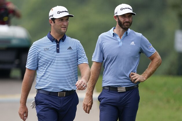 Jon Rahm, left, Dustin Johnson, right, walk to the tee during the first round of the Tour Championship golf tournament at East Lake Golf Club in Atlanta, Friday, Sept. 4, 2020. (AP Photo/John Bazemore)