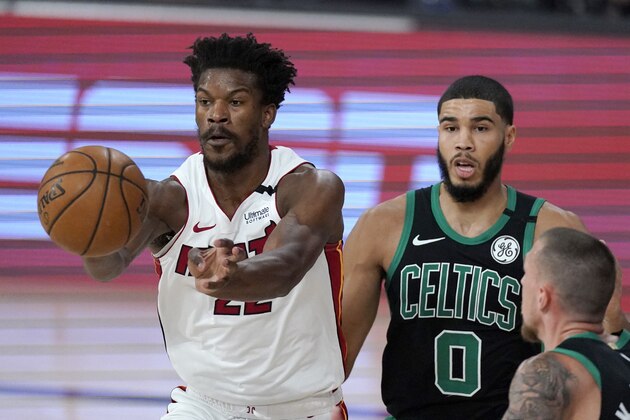 Miami Heat's Jimmy Butler (22) makes a pass in front of Boston Celtics' Jayson Tatum (0) and others during the first half of an NBA conference final playoff basketball game, Tuesday, Sept. 15, 2020, in Lake Buena Vista, Fla. (AP Photo/Mark J. Terrill)