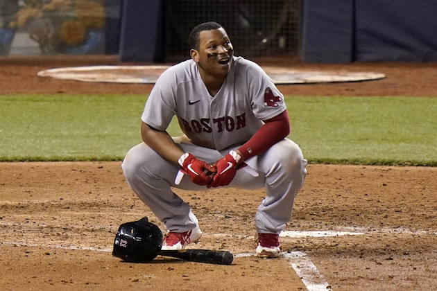 Boston Red Sox's Rafael Devers kneels at the plate after striking out with the bases loaded during the sixth inning of a baseball game against the Miami Marlins, Wednesday, Sept. 16, 2020, in Miami. The Marlins won 8-4. (AP Photo/Lynne Sladky)