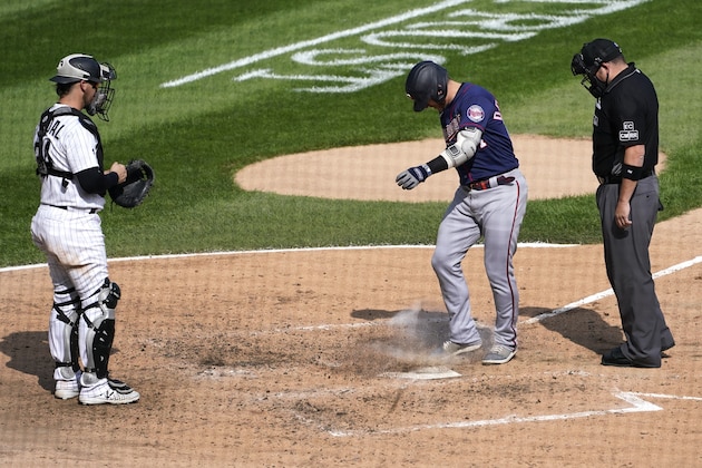 Minnesota Twins' Josh Donaldson kicks dirt on home plate after his home run prompting umpire Dan Bellino to eject him from the game as Chicago White Sox catcher Yasmani Grandal watches during the sixth inning of a baseball game Thursday, Sept. 17, 2020, in Chicago. (AP Photo/Charles Rex Arbogast)