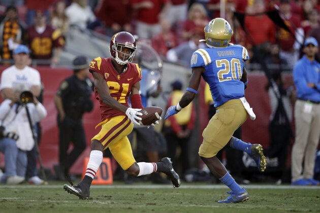 Southern California wide receiver Tyler Vaughns (21) makes a touchdown catch in front of UCLA defensive back Elisha Guidry (20) during the second half of an NCAA college football game, Saturday, Nov. 23, 2019, in Los Angeles. (AP Photo/Marcio Jose Sanchez)
