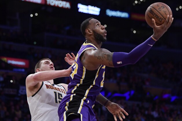Los Angeles Lakers forward LeBron James, right, shoots as Denver Nuggets center Nikola Jokic defends during the second half of an NBA basketball game Wednesday, March 6, 2019, in Los Angeles. The Nuggets won 115-99. (AP Photo/Mark J. Terrill)