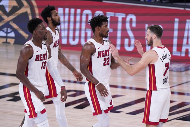 Miami Heat's Bam Adebayo (13), Derrick Jones Jr., left rear, Jimmy Butler (22) and Goran Dragic (7) celebate after their NBA conference final playoff basketball game against the Boston Celtics on Thursday, Sept. 17, 2020, in Lake Buena Vista, Fla. (AP Photo/Mark J. Terrill)