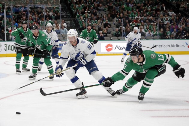 Dallas Stars center Mattias Janmark, right reaches for the puck in front of Tampa Bay Lightning center Steven Stamkos, left, during the second period of an NHL hockey game in Dallas, Monday, Jan. 27, 2020. (AP Photo/Ray Carlin)