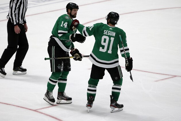 Dallas Stars left wing Jamie Benn (14) gets congratulated on his hat trick against the Carolina Hurricanes by center Tyler Seguin (91) during the third period of an NHL hockey game in Dallas, Tuesday, Feb. 11, 2020. Dallas defeated Carolina 4-1. (AP Photo/Michael Ainsworth)