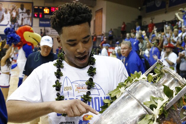 Kansas guard Devon Dotson holds the Maui Invitational trophy Wednesday, Nov. 27, 2019, in Lahaina, Hawaii. Kansas defeated Dayton in 90-84 in overtime in an NCAA college basketball game for the title. (AP Photo/Marco Garcia)