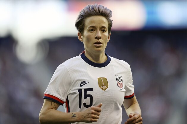 FILE - In this March 8, 2020, file photo, United States forward Megan Rapinoe (15) runs over to take a corner kick during the second half of a SheBelieves Cup soccer match against Spain, in Harrison, N.J. U.S. national team players Megan Rapinoe, Tobin Heath and Christen Press have opted out of the National Women's Soccer League tournament kicking off this weekend in Utah.  (AP Photo/Steve Luciano, File)
