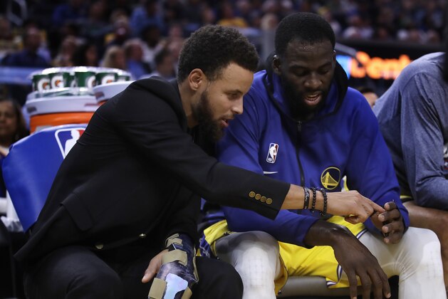 Golden State Warriors' Stephen Curry, left, points to the fingers of teammate Draymond Green during the first half of an NBA basketball game against the Boston Celtics, Friday, Nov. 15, 2019, in San Francisco. (AP Photo/Ben Margot)