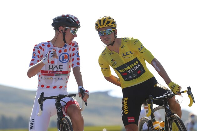 Slovenia's Primoz Roglic, wearing the overall leader's yellow jersey speaks with Slovenia's Tadej Pogacar, wearing the best climber's dotted jersey at the start of the stage 18 of the Tour de France cycling race over 175 kilometers (108.7 miles) from Meribel to La Roche-sur-Foron, France, Thursday, Sept. 17, 2020. (AP Photo/Thibault Camus)