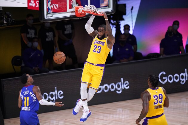 Denver Nuggets guard Monte Morris (11) and Los Angeles Lakers' Dwight Howard (39) look on as LeBron James (23) dunks in the first half an NBA conference final playoff basketball game Friday, Sept. 18, 2020, in Lake Buena Vista, Fla. (AP Photo/Mark J. Terrill)