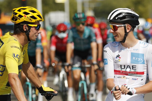 Slovenia's Primoz Roglic, wearing the yellow jersey of the overall leader, and Slovenia's Tadej Pogacar, wearing the best young rider's white jersey, talk at the start of the stage 19 of the Tour de France cycling race over 166 kilometers (103 miles), with start in Bourg-en-Bresse and finish in Champagnole, Friday, Sept. 18, 2020. (AP Photo/Christophe Ena)