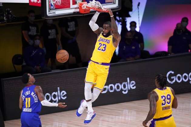 Denver Nuggets guard Monte Morris (11) and Los Angeles Lakers' Dwight Howard (39) look on as LeBron James (23) dunks in the first half an NBA conference final playoff basketball game Friday, Sept. 18, 2020, in Lake Buena Vista, Fla. (AP Photo/Mark J. Terrill)