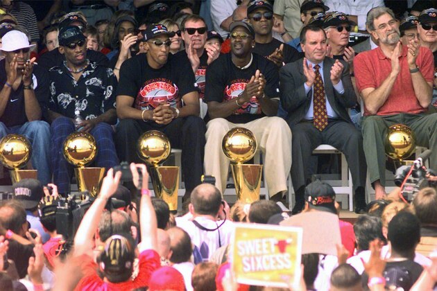 FILE - In this June 16, 1998, file photo, NBA Champions, from left: Ron Harper, Dennis Rodman, Scottie Pippen, Michael Jordan and coach Phil Jackson are joined on stage by Chicago Mayor Richard Daley, second from right, during a city-wide rally in Chicago to celebrate the Chicago Bulls 6th NBA championship. Jordan described his final NBA championship season with the Chicago Bulls as a “trying year.” “We were all trying to enjoy that year knowing it was coming to an end,” Jordan told Good Morning America on Thursday, April 16, 2020.  (AP Photo/Beth A. Keiser, File)