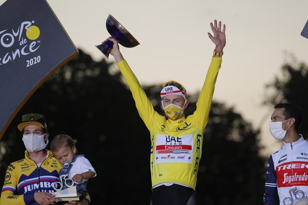 Tour de France winner Tadej Pogacar, wearing the overall leader's yellow jersey, second placed Primoz Roglic of Slovenia, left, and third placed Richie Porte of Australia, celebrate on the podium after the twenty-first and last stage of the Tour de France cycling race over 122 kilometers (75.8 miles), from Mantes-la-Jolie to Paris, France, Sunday, Sept. 20, 2020. (AP Photo/Christophe Ena)