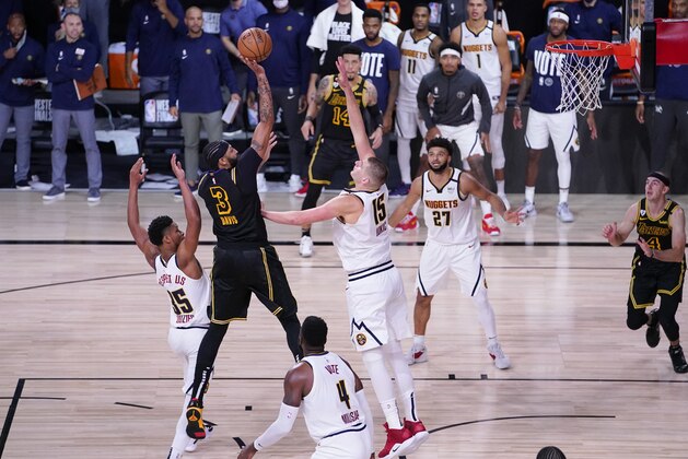Los Angeles Lakers' Anthony Davis (3) shoots between Denver Nuggets' PJ Dozier, left, and Nikola Jokic (15) during the second half of an NBA conference final playoff basketball game Sunday, Sept. 20, 2020, in Lake Buena Vista, Fla. The Lakers won 105-103. (AP Photo/Mark J. Terrill)