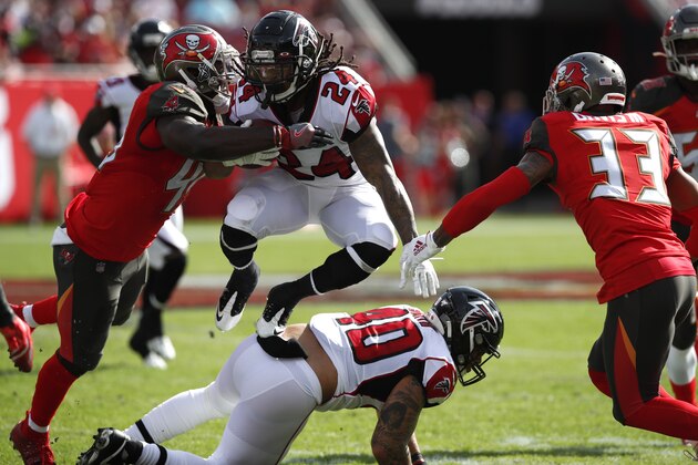 Atlanta Falcons running back Devonta Freeman (24) leaps over teammate Keith Smith (40) against the Tampa Bay Buccaneers during an NFL football game Sunday, Dec. 29, 2019, in Tampa, Fla. The Falcons won the game 28-22 in overtime. (Jeff Haynes/AP Images for Panini)