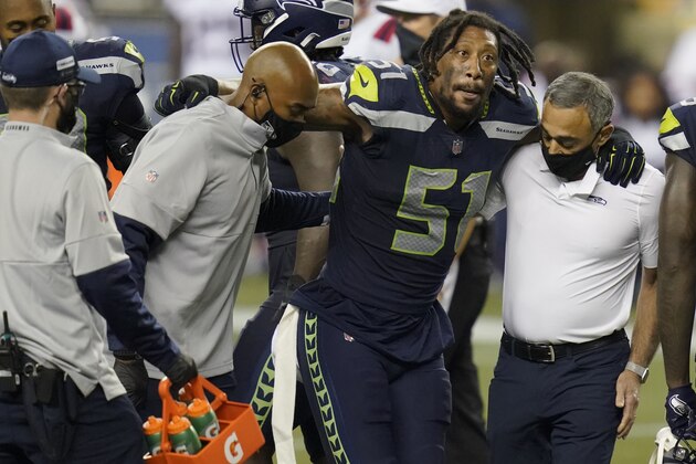 Seattle Seahawks linebacker Bruce Irvin is helped off the field after an injury during the second half of an NFL football game against the New England Patriots, Sunday, Sept. 20, 2020, in Seattle. (AP Photo/Elaine Thompson)