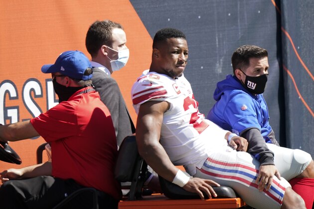 New York Giants running back Saquon Barkley (26) is carted to the locker room after being injured during the first half of an NFL football game against the Chicago Bears in Chicago, Sunday, Sept. 20, 2020. (AP Photo/Nam Y. Huh)