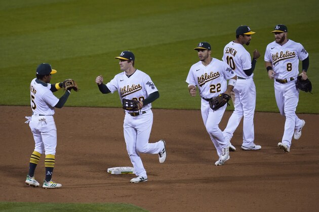 Oakland Athletics' Tony Kemp, Mark Canha, Ramon Laureano, Marcus Semien and Robbie Grossman, from left, greet each other at the end of a baseball game against the San Francisco Giants on Friday, Sept. 18, 2020, in Oakland, Calif. Oakland won 6-0. (AP Photo/Eric Risberg)