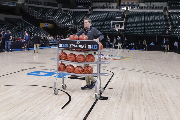 Basketballs are removed from the court at Bankers Life Fieldhouse, in Indianapolis, Thursday, March 12, 2020, after the Big Ten Conference announced that remainder of the men's NCAA college basketball games tournament was canceled. (AP Photo/Michael Conroy)
