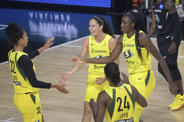 Seattle Storm forward Alysha Clark (32), guard Sue Bird, center, center Ezi Magbegor, right, and guard Jewell Loyd (24) huddle after a score during the first half of a WNBA basketball game against the New York Liberty, Tuesday, Aug. 18, 2020, in Bradenton, Fla. (AP Photo/Phelan M. Ebenhack)