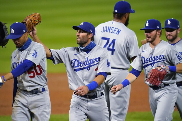 Los Angeles Dodgers right fielder Mookie Betts, shortstop Chris Taylor and second baseman Gavin Lux celebrate the team's win in a baseball game against the Colorado Rockies on Saturday, Sept. 19, 2020, in Denver. The Dodgers won 6-1. (AP Photo/David Zalubowski)