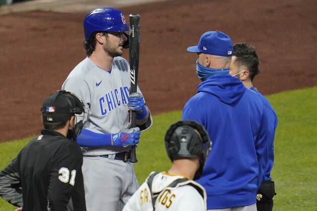Chicago Cubs' Kris Bryant, top left, talks with manager David Ross, front right, and a team trainer during an at-bat during the second inning of a baseball game against the Pittsburgh Pirates in Pittsburgh, Monday, Sept. 21, 2020. Bryant left the game after grounding out. (AP Photo/Gene J. Puskar)
