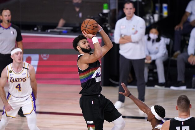 Denver Nuggets guard Jamal Murray, center, goes up to shoot a 3-point basket as Los Angeles Lakers' Alex Caruso (4) looks on late in the second half of Game 3 of the NBA basketball Western Conference final Tuesday, Sept. 22, 2020, in Lake Buena Vista, Fla. (AP Photo/Mark J. Terrill)