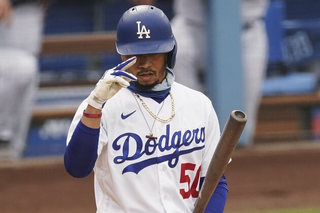 Los Angeles Dodgers' Mookie Betts salutes toward the Houston Astros bench as he steps up to bat during the first inning of the team's baseball game against the Houston Astros at Dodger Stadium on Saturday, Sept. 12, 2020, in Los Angeles. (AP Photo/Ashley Landis)