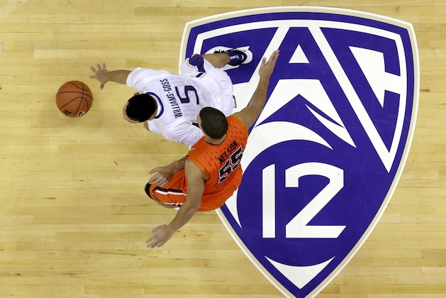 Washington's Nigel Williams-Goss (5) dribbles past Oregon State's Roberto Nelson and across a Pac-12 logo in the first half of an NCAA men's college basketball game Saturday, Jan. 25, 2014, in Seattle. (AP Photo/Elaine Thompson)