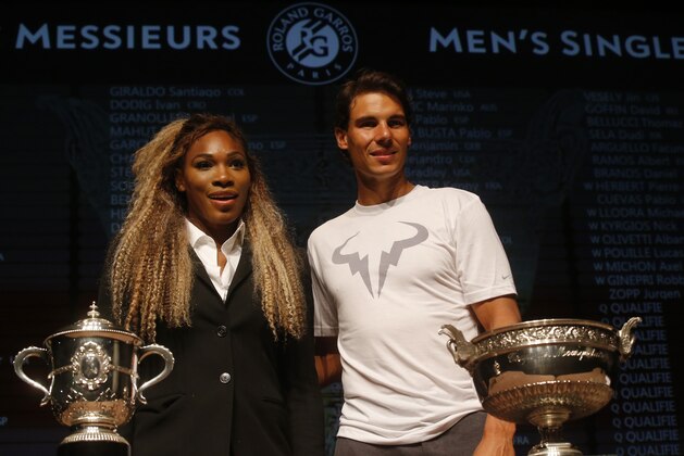 Defending champions Serena Williams, of the U.S, left, and Spain's Rafael Nadal pose during the draw for the French Open Tennis tournament, at the Roland Garros stadium in Paris, Friday, May 23, 2014. The French Open tennis tournament starts Sunday. At left is the women's trophy, at right, the men's trophy. (AP Photo/Michel Euler)