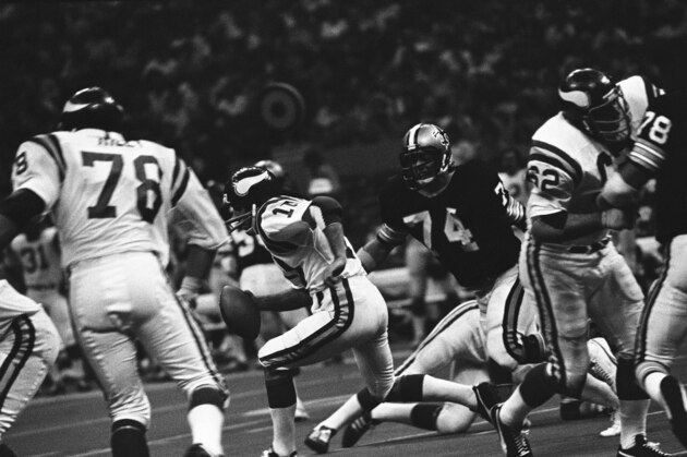 Minnesota Viking quarterback Fran Tarkenton steps out up the middle in heavy traffic in the New Orleans Superdome on Sunday, Sept. 12, 1976 as New Orleans Saints defensive tackle Derland Moore (74) gives chase. Tarkenton passed for 221 yards as the Vikings beat the Saints 40-9. (AP Photo)