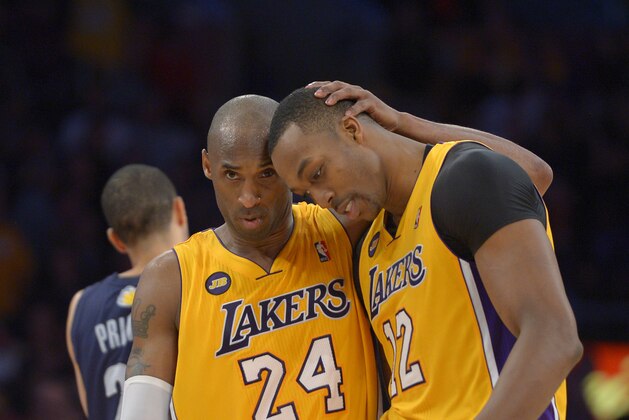Los Angeles Lakers guard Kobe Bryant, left, hugs center Dwight Howard in the closing seconds of their NBA basketball game against the Memphis Grizzlies, Friday, April 5, 2013, in Los Angeles. The Lakers won 86-84.  (AP Photo/Mark J. Terrill)